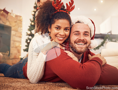 Image of Christmas, portrait and happy couple in home on floor, bonding and together. Xmas, smile and face of man with African woman, interracial and enjoying time for party, celebration and winter holiday