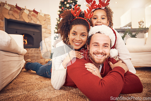 Image of Christmas, happy family and portrait in home on floor, bonding and together. Xmas, smile and face of parents with girl, interracial and African mom with father for party, celebration and holiday