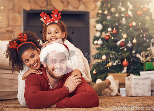 Image of Christmas, portrait and happy family in house on floor, bonding and together. Xmas, smile and face of parents with child, interracial and African mother with father for party, celebration and holiday