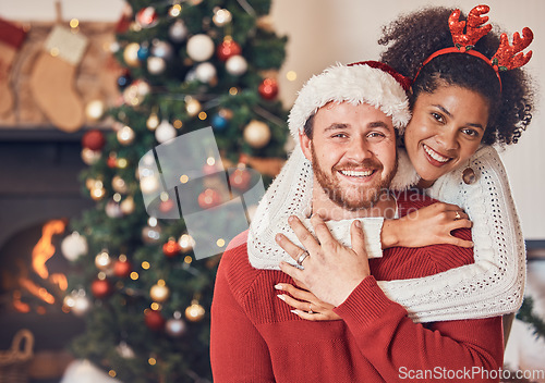 Image of Christmas, portrait and happy couple in home, hug and bonding together. Xmas, smile and face of man with African woman, interracial and enjoying quality time for party, celebration and winter holiday