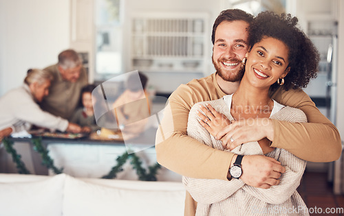 Image of Couple, portrait and hug with love on christmas in family home for quality time with interracial people. Love, embrace and man or woman with happy face in kitchen for bonding during festive season.