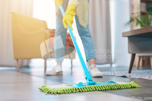 Image of Woman, hands and cleaning floor with mop in living room for hygiene, bacteria or germ removal at home. Female person, housekeeper or maid in domestic service, dirt or dust for disinfection in house