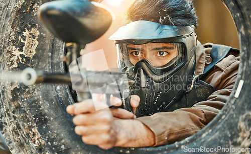 Image of Paintball, shooting and man in action with gun for tournament, competition and battle in nature. Camouflage, military and male person aim in outdoor arena for training, adventure game or challenge