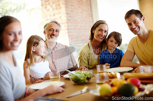 Image of Home is where our family is. A portrait of a happy multi-generational family eating a meal together at home.