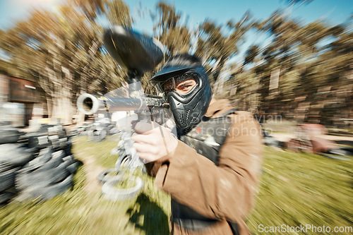 Image of Paintball, shooting and gaming with man in playground for battlefield, mission or soldier with blur. Sports, games and fast with person and gun in arena for challenge, adventure and warrior training