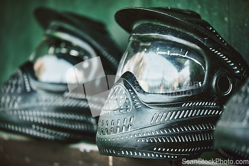 Image of Mask, helmet and paintball with still life equipment on a table outdoor ready for combat training or war games. Safety, sports and military protection with uniform headwear closeup for competition