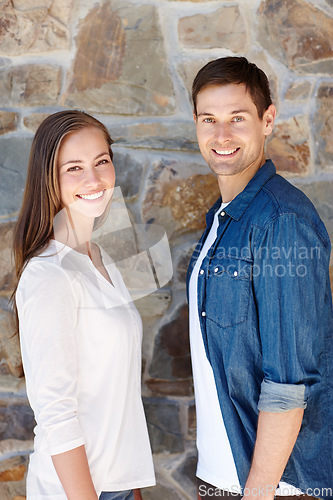 Image of They make a perfect pair. Portrait of a young couple standing outside.