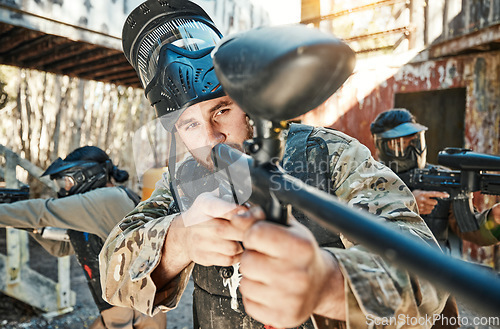 Image of Paintball team, gun and man aim, focus or shooting at target, competition or battlefield conflict, fight or mission. Military group, hobby game or male shooter point weapon in war, training or battle