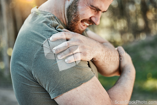 Image of Man, outdoor and shoulder pain with fitness, injury and tension with sports, workout and accident. Male person, guy and athlete with injured arm, park and strain with inflammation with emergency