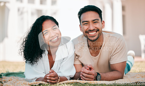 Image of Portrait, smile and couple on picnic blanket outdoor, bonding and relax together in backyard garden at home. Face, interracial and Asian man and woman with love, happy and quality time on grass lawn