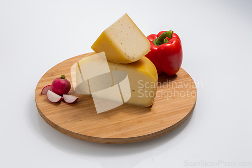 Image of Bosnian traditional cheese served on a wooden container with peppers, parade and onions isolated on a white background