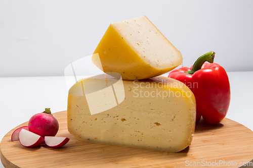 Image of Bosnian traditional cheese served on a wooden container with peppers, parade and onions isolated on a white background