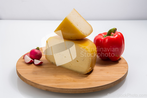 Image of Bosnian traditional cheese served on a wooden container with peppers, parade and onions isolated on a white background