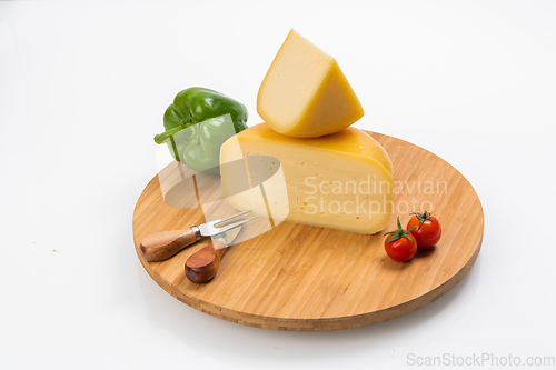 Image of Bosnian traditional cheese served on a wooden container with peppers, parade and onions isolated on a white background