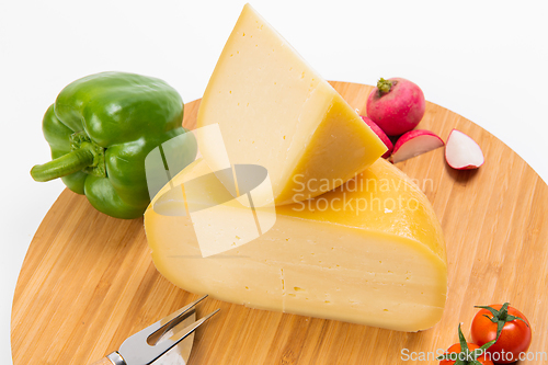 Image of Bosnian traditional cheese served on a wooden container with peppers, parade and onions isolated on a white background