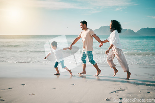 Image of Running, flare and a family holding hands on the beach while walking during travel, vacation or bonding. Love, children and parents on sand at the coast by an ocean or sea for summer holiday fun