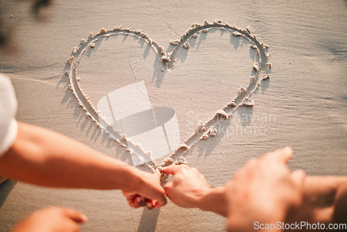 Image of Hands, drawing and heart on beach sand for care and couple with kindness or support together with emoji. Draw, love or writing symbol in the shape of loving, caring or line in the for romance