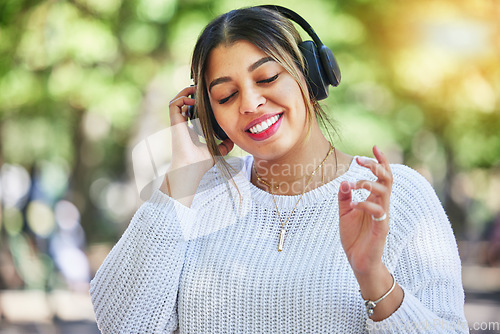Image of Outdoor, music and woman with headphones, listening and streaming audio with happiness, stress relief and dance. Female person, radio and happy girl with a headset, smile and online sounds in a park