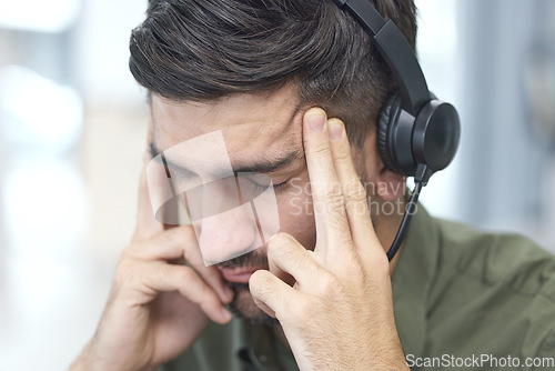 Image of Man, headache and call center in stress, mistake or client problem in customer service or support at office. Male person, consultant or agent with headphones and bad head pain in burnout at workplace