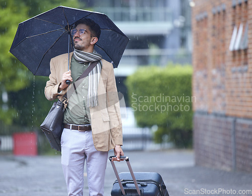 Image of Thinking, travel and a man with an umbrella and suitcase in the rain in the morning. Serious, winter and a person with luggage for a vacation, immigration or holiday in the city for commute ideas