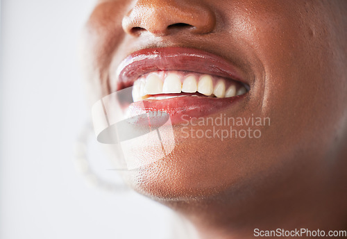 Image of Happy, lips and beauty with a woman closeup in studio on a gray background for makeup or cosmetics. Smile, mouth and teeth with a confident female person posing to promote dental health or hygiene