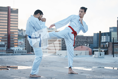 Image of Men, fight and kick in karate class, training and speed with sparring partner, workout and morning on city rooftop. Martial arts team, contest and fitness with block for exercise, coaching or sports