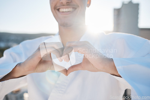 Image of Heart in hands, karate and man in city for training, exercise and sports in morning outdoors. Happy, love emoji and male person with hand gesture for care in town for combat, martial arts and workout