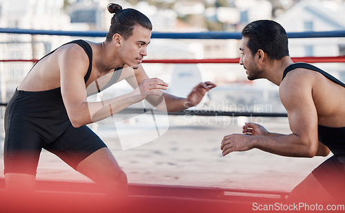 Image of Men, wrestling and sport fight in ring with challenge, patient and focus for contest in metro cbd. Combat athlete, martial arts coach and thinking for mma, competition or strategy in workout on roof