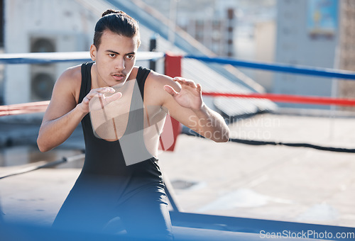 Image of Man, wrestler and fight with in ring training on rooftop with for sport competition in outdoor. Athlete, fitness and wrestling with martial arts for workout in city with serious face for contest.