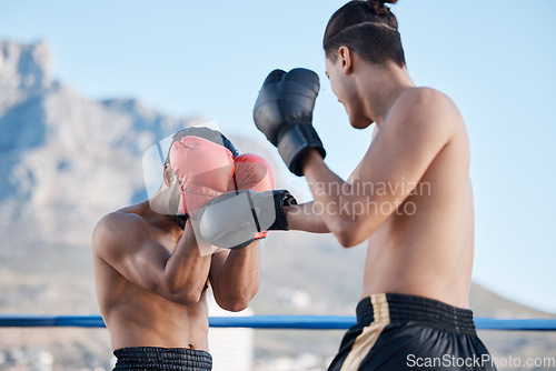 Image of Punch, boxing match or men in sports training, exercise or fist punching with strong power in workout. Fitness, boxers or combat athletes fighting in a mma practice match in ring on rooftop in city