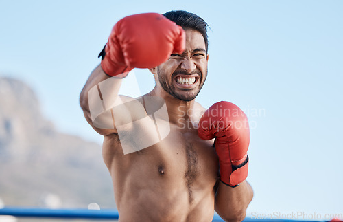 Image of face, man or angry boxer punching in training, exercise or workout with strong boxing power outdoors. Serious fighter, fitness or Asian combat sports athlete fighting in mma practice match with pain