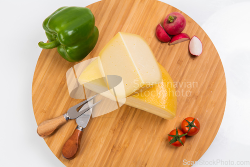 Image of Bosnian traditional cheese served on a wooden container with peppers, parade and onions isolated on a white background