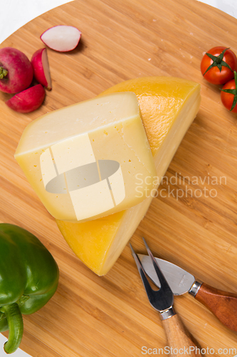 Image of Bosnian traditional cheese served on a wooden container with peppers, parade and onions isolated on a white background