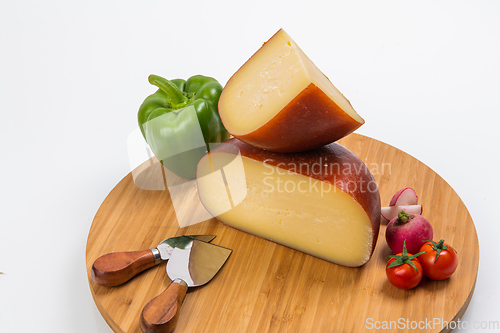 Image of Bosnian traditional cheese served on a wooden container with peppers, parade and onions isolated on a white background