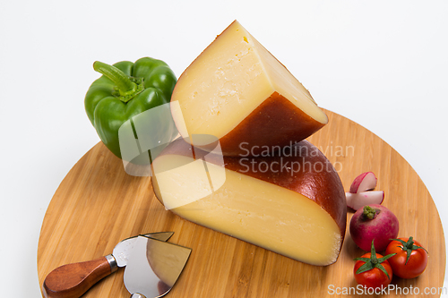 Image of Bosnian traditional cheese served on a wooden container with peppers, parade and onions isolated on a white background