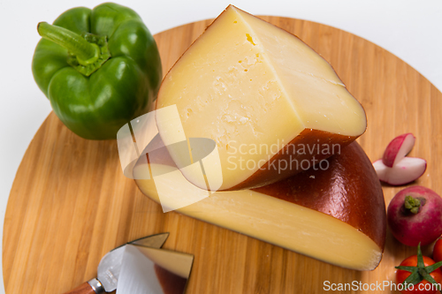 Image of Bosnian traditional cheese served on a wooden container with peppers, parade and onions isolated on a white background