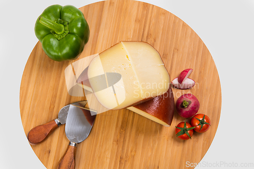 Image of Bosnian traditional cheese served on a wooden container with peppers, parade and onions isolated on a white background