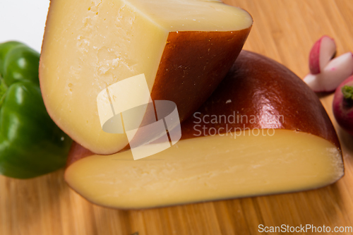 Image of Bosnian traditional cheese served on a wooden container with peppers, parade and onions isolated on a white background