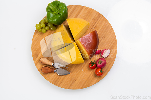 Image of Bosnian traditional cheese served on a wooden container with peppers, parade and onions isolated on a white background