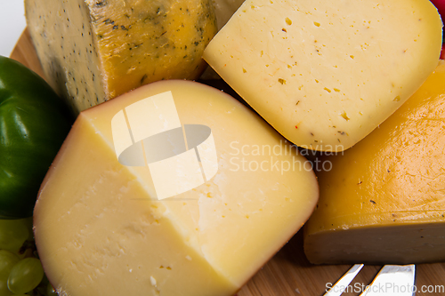 Image of Bosnian traditional cheese served on a wooden container with peppers, parade and onions isolated on a white background