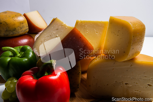 Image of Bosnian traditional cheese served on a wooden container with peppers, parade and onions isolated on a white background