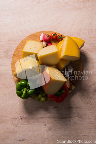 Image of Bosnian traditional cheese served on a wooden container with peppers, parade and onions isolated on a white background