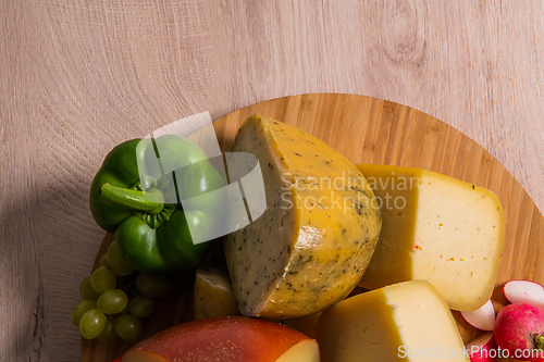 Image of Bosnian traditional cheese served on a wooden container with peppers, parade and onions isolated on a white background