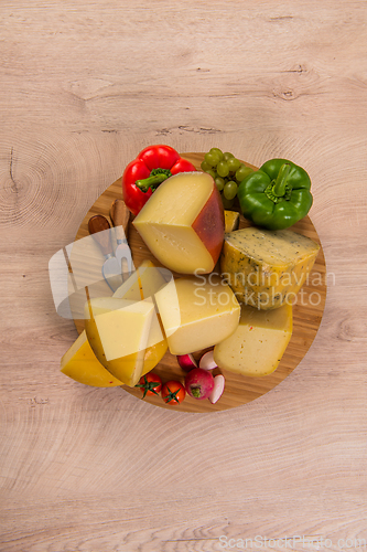 Image of Bosnian traditional cheese served on a wooden container with peppers, parade and onions isolated on a white background