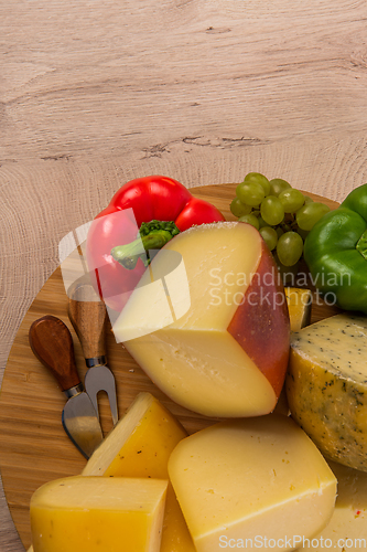 Image of Bosnian traditional cheese served on a wooden container with peppers, parade and onions isolated on a white background