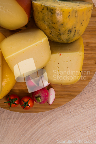 Image of Bosnian traditional cheese served on a wooden container with peppers, parade and onions isolated on a white background