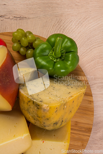 Image of Bosnian traditional cheese served on a wooden container with peppers, parade and onions isolated on a white background