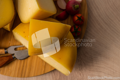 Image of Bosnian traditional cheese served on a wooden container with peppers, parade and onions isolated on a white background