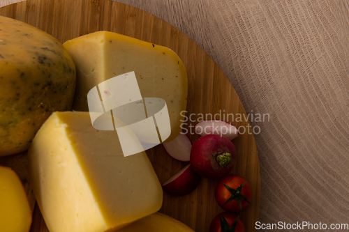 Image of Bosnian traditional cheese served on a wooden container with peppers, parade and onions isolated on a white background