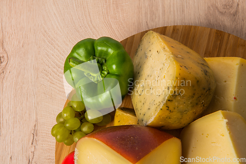 Image of Bosnian traditional cheese served on a wooden container with peppers, parade and onions isolated on a white background